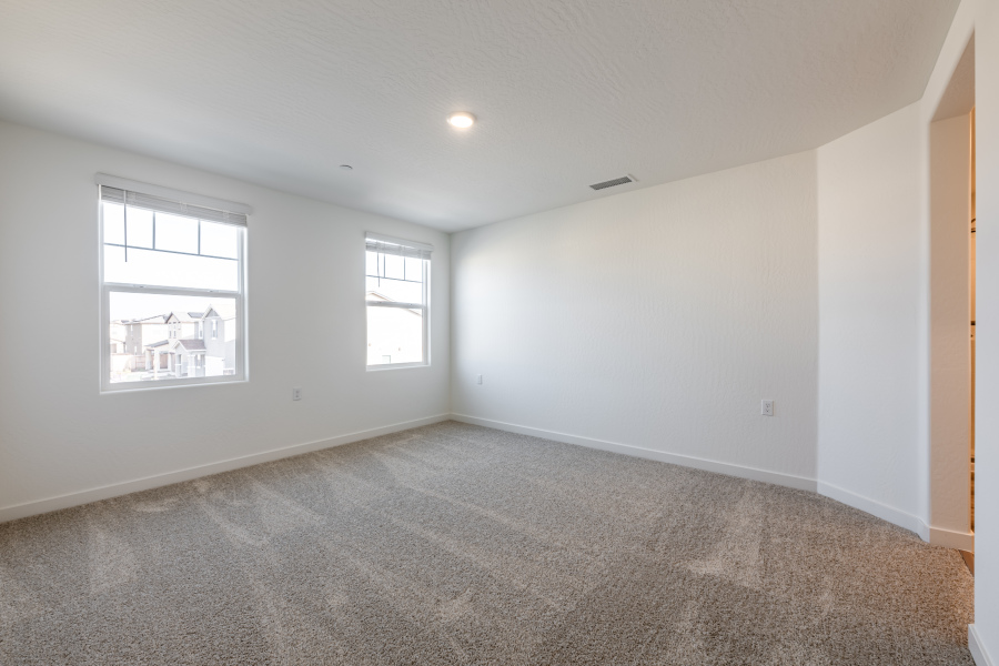 A room with a carpet and windows.