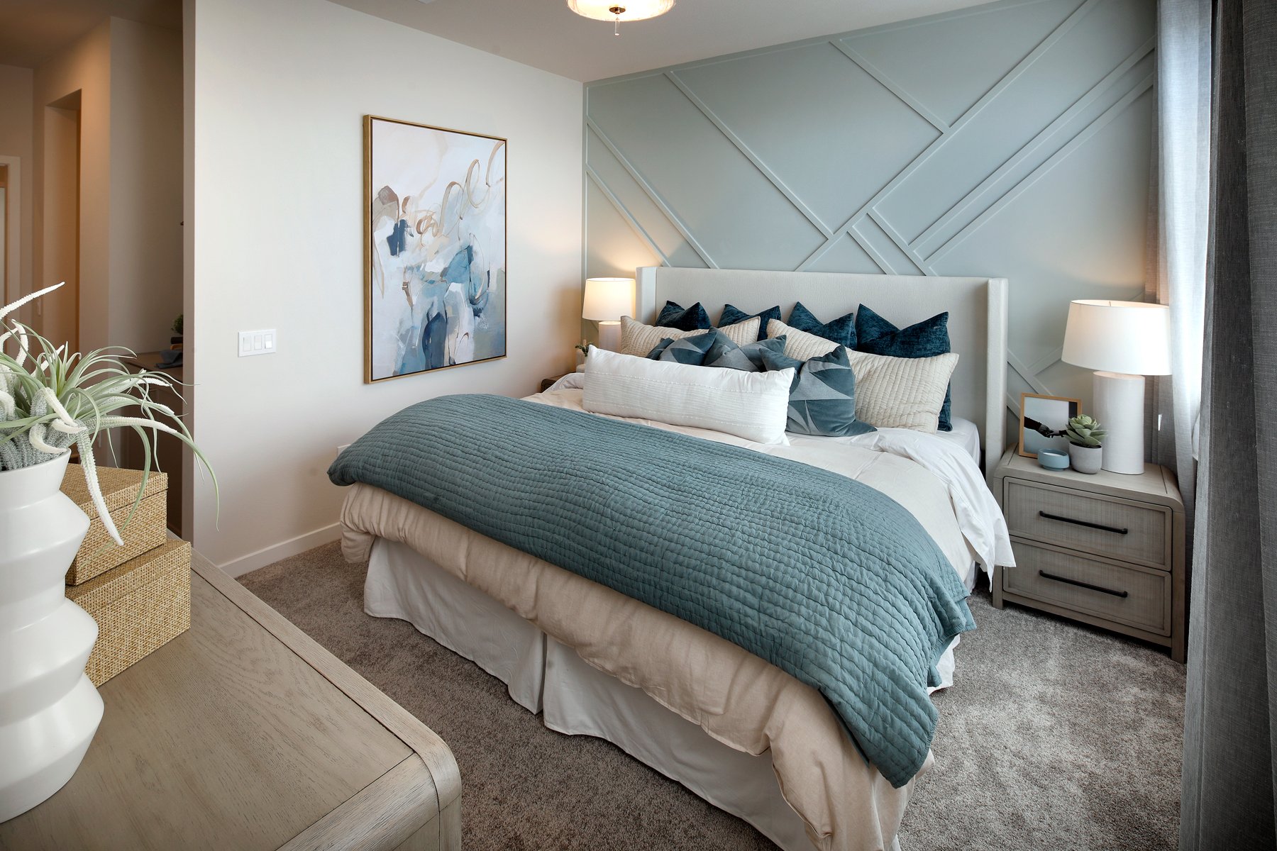 A bedroom with a bed and lamps.