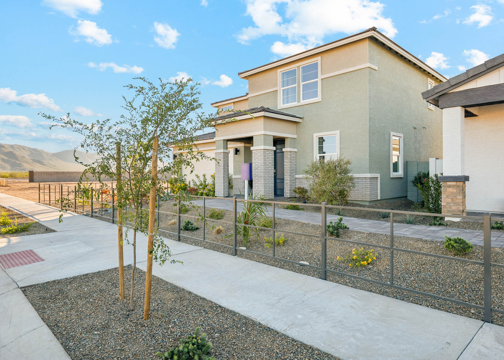 A fenced in yard with a tree and a house in the background.