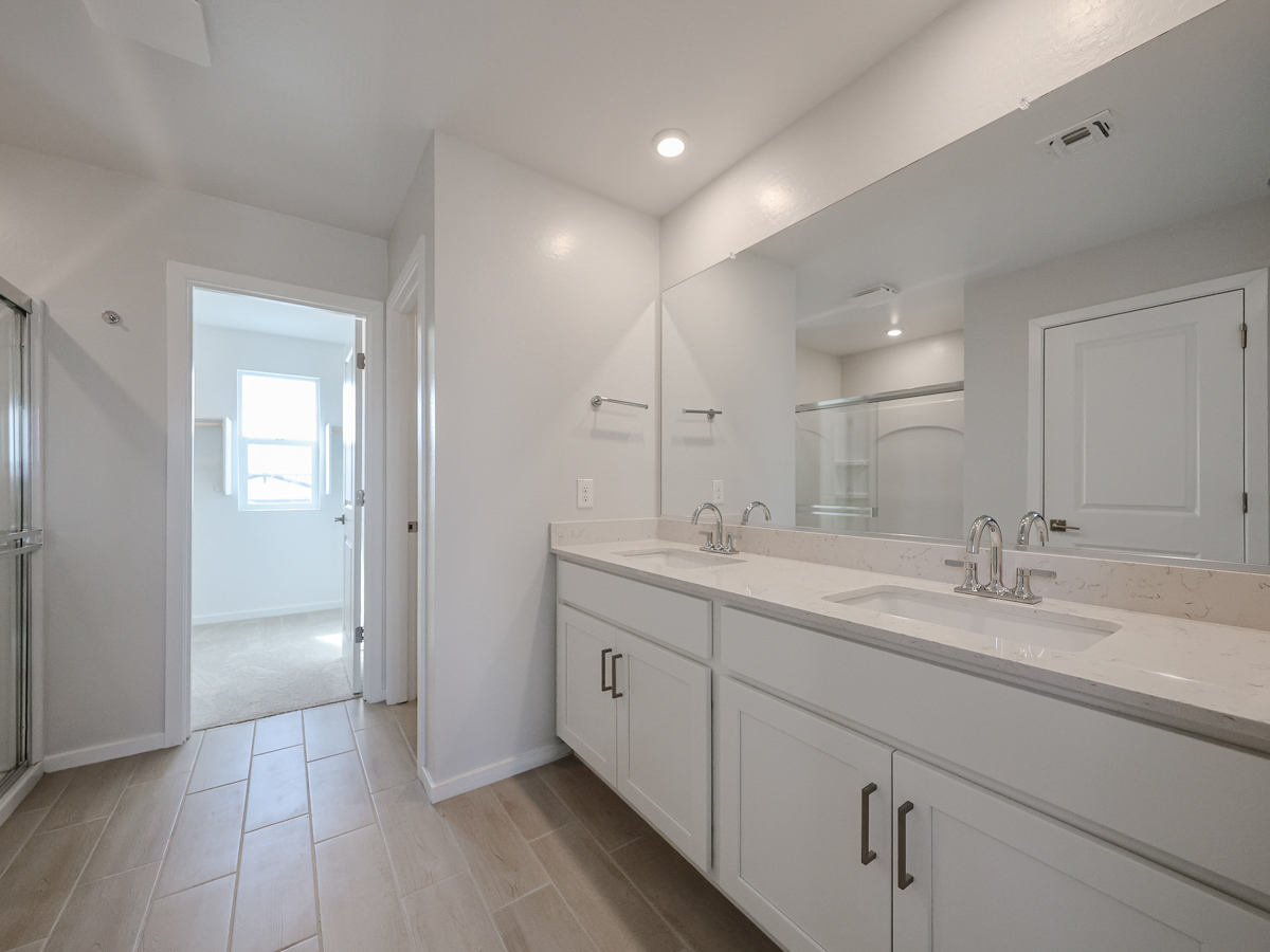 A bathroom with white cabinets.