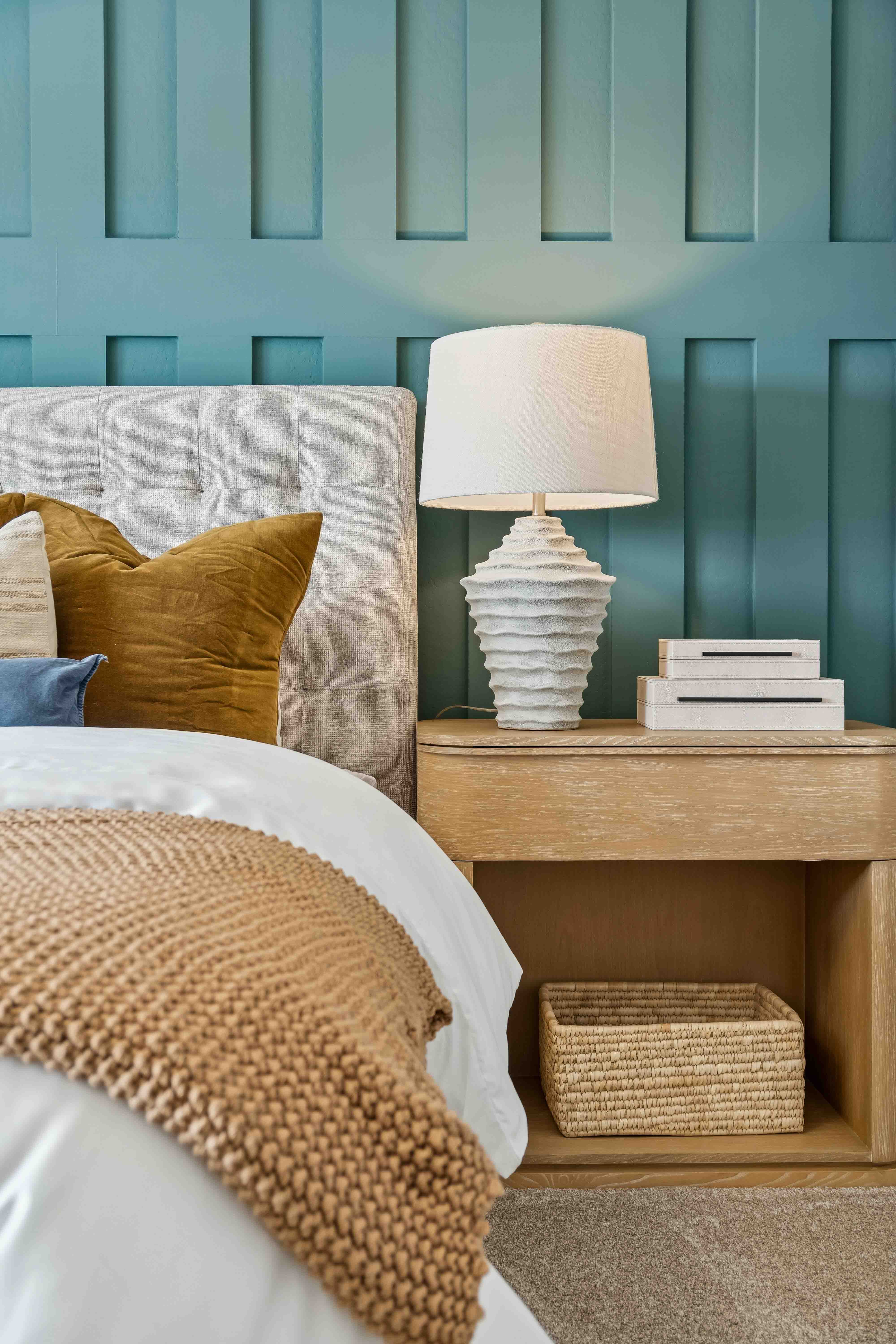 Interior photo of the primary bedroom editorial close-up photo of bed, lamp and colorful dopamine decor with textured elements for added depth to this wholesome home design in the model home Oak floor plan in The Highlands Collection at Skyline Village in San Tan Valley, Arizona by Century Communities New Construction Homes for Sale in Phoenix