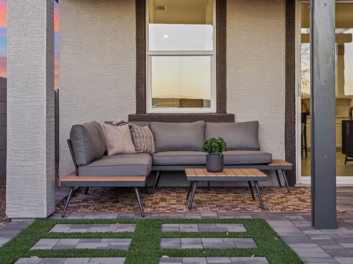 A couch and a coffee table outside a building.