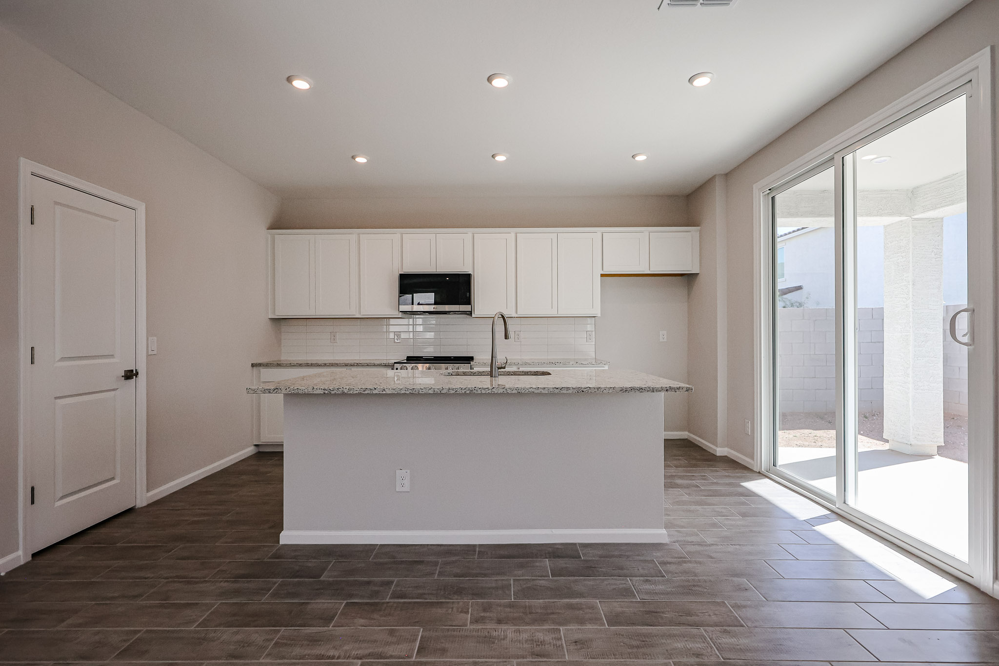 A kitchen with a large glass door.
