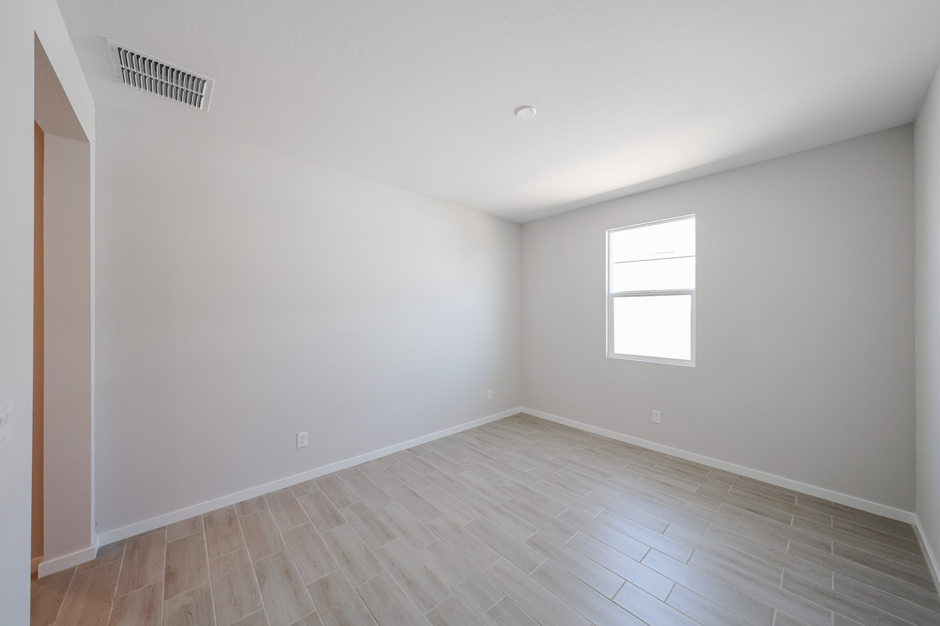 A room with a wood floor and windows.