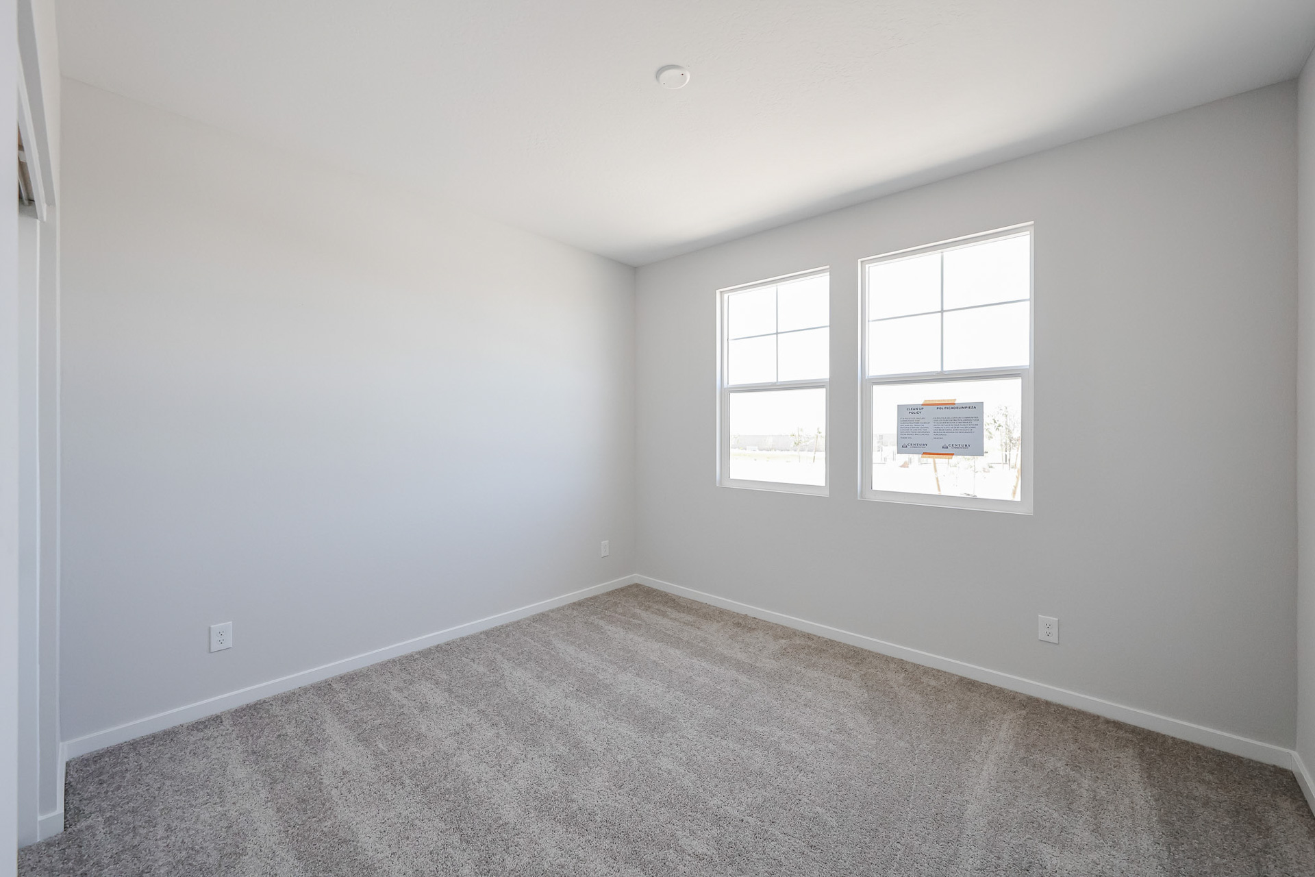 A room with a window and a carpet.