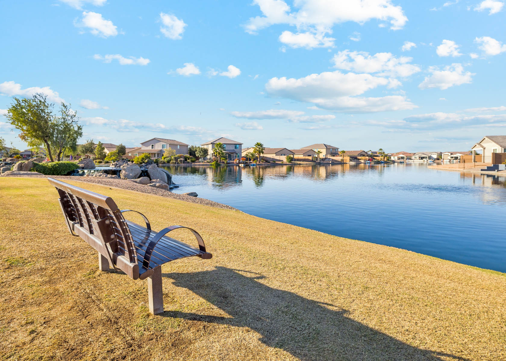 A bench sits by a body of water.