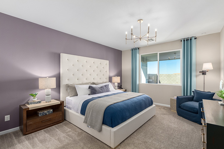 A bedroom with a bed and a chair.