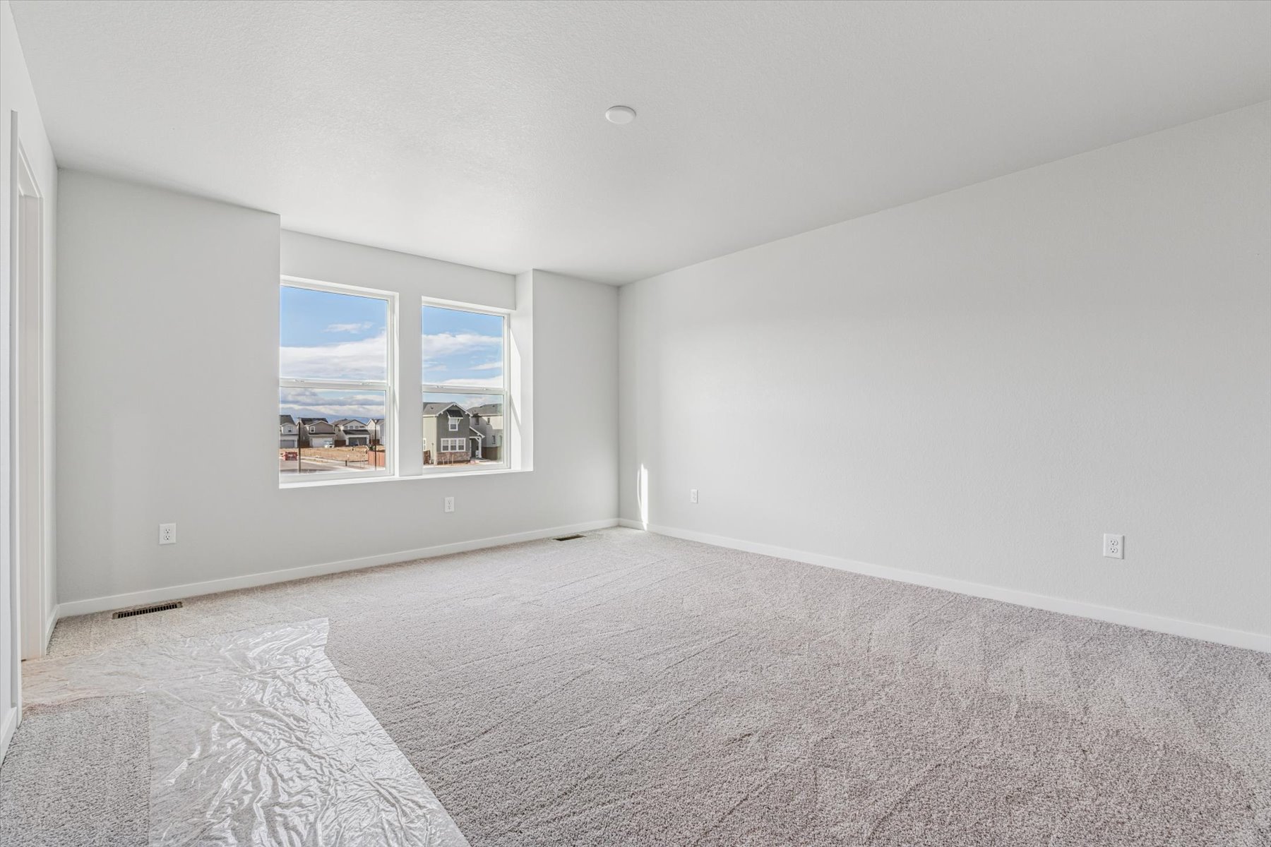 A room with a carpet and a window.