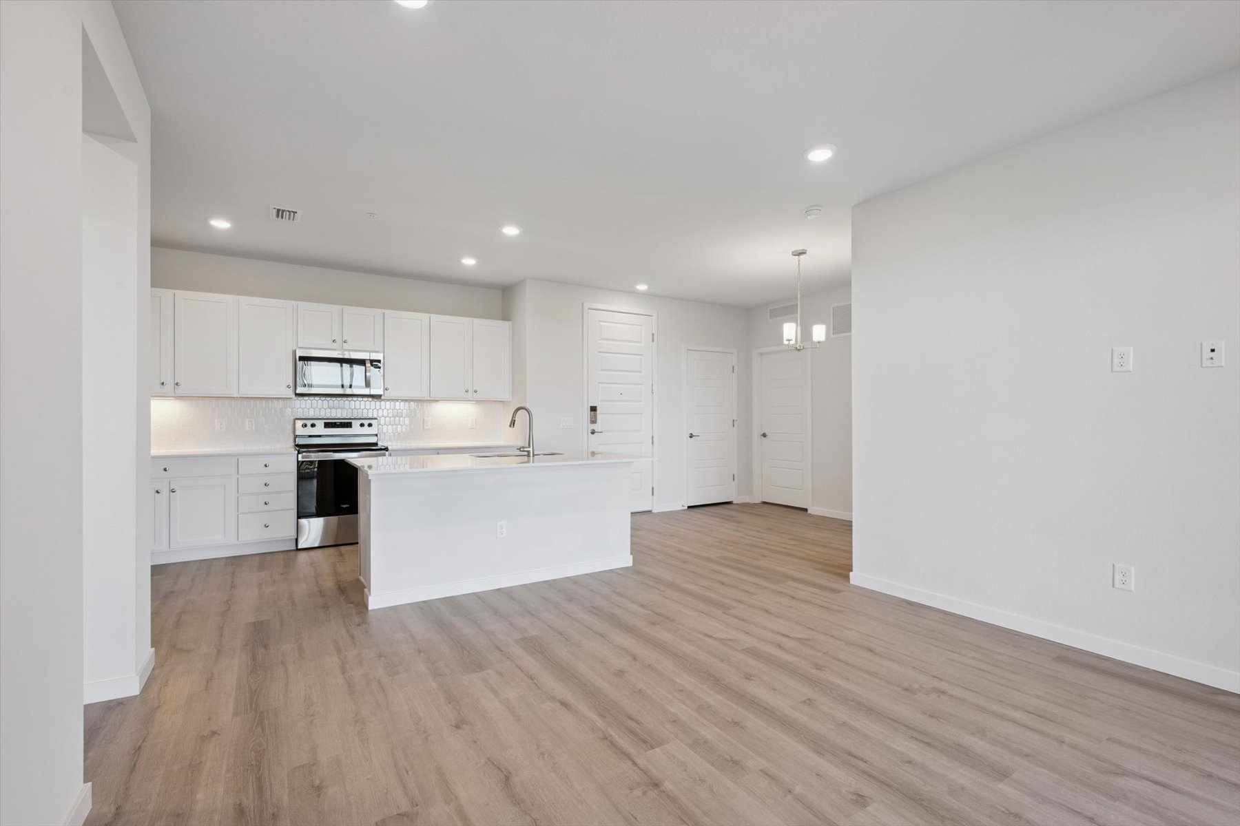 A kitchen with white cabinets.