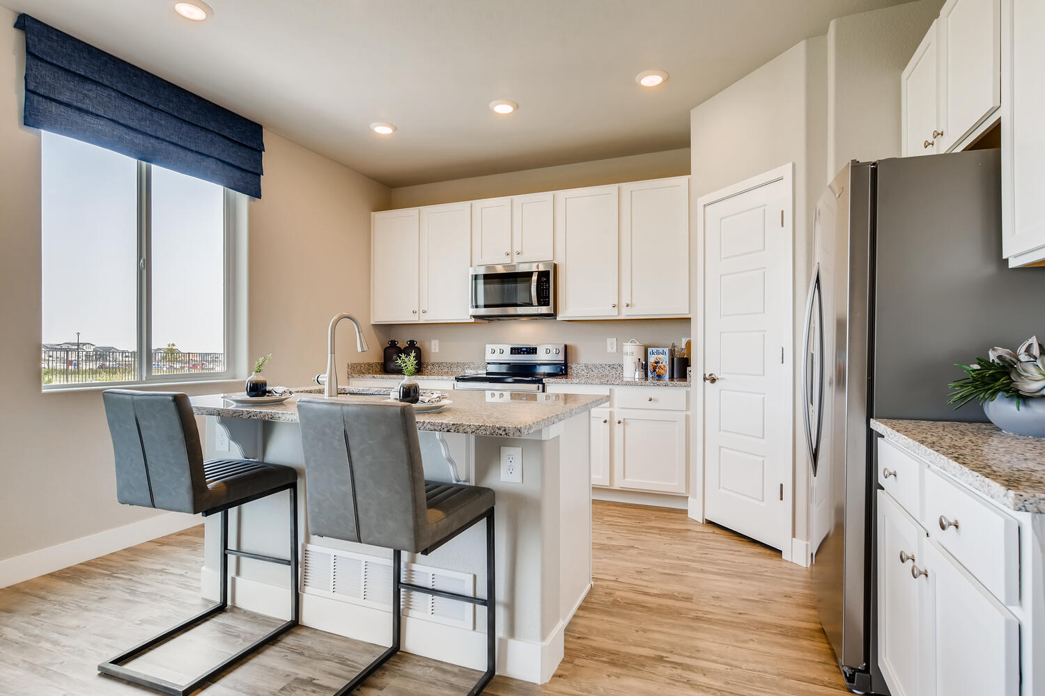 A kitchen with white cabinets.
