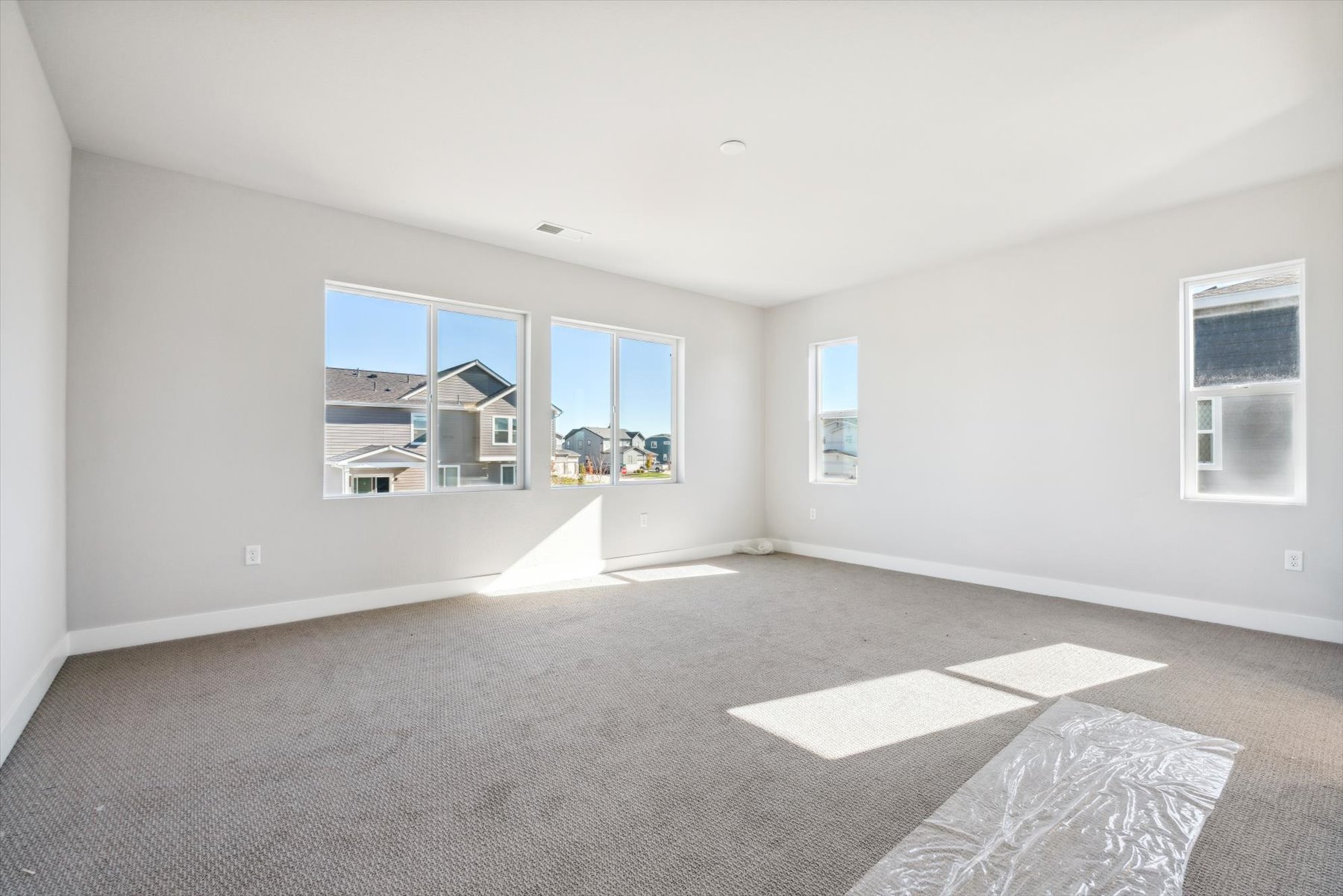 A large empty room with a rug.