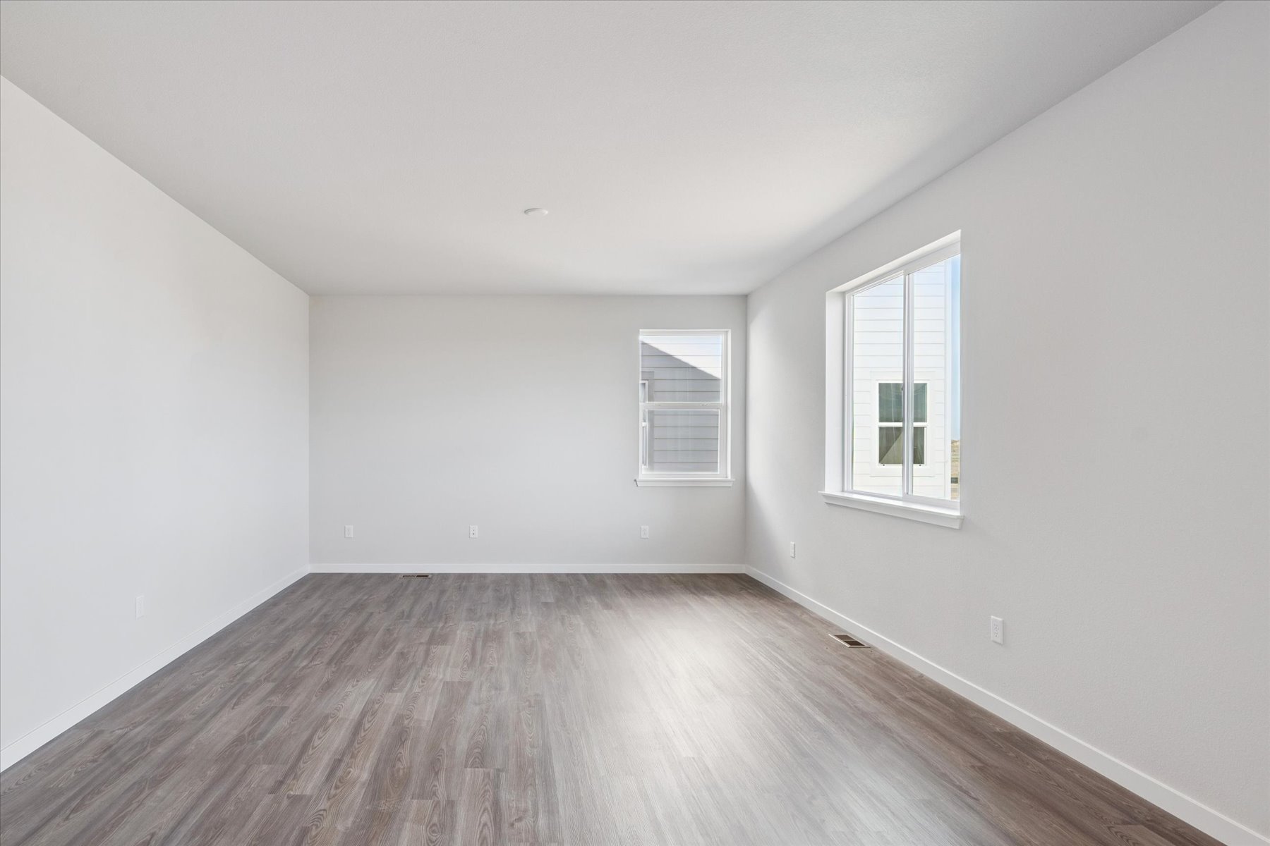 A room with a wood floor and windows.