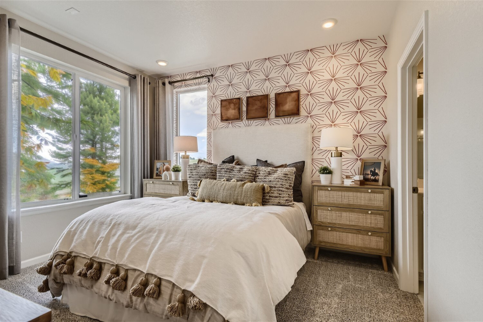 A bedroom with a bed and lamps.