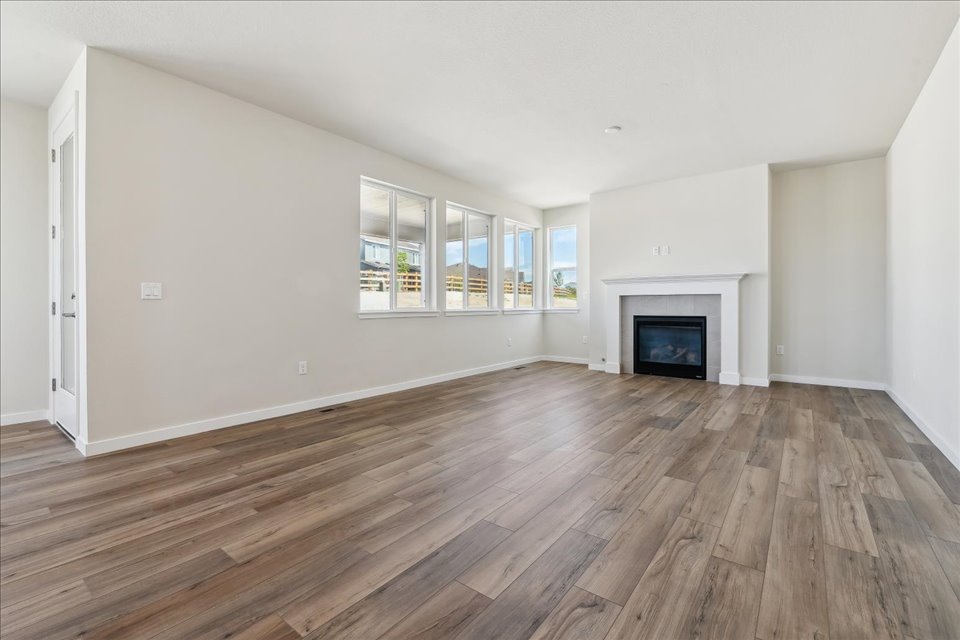 A room with a fireplace and wood floors.