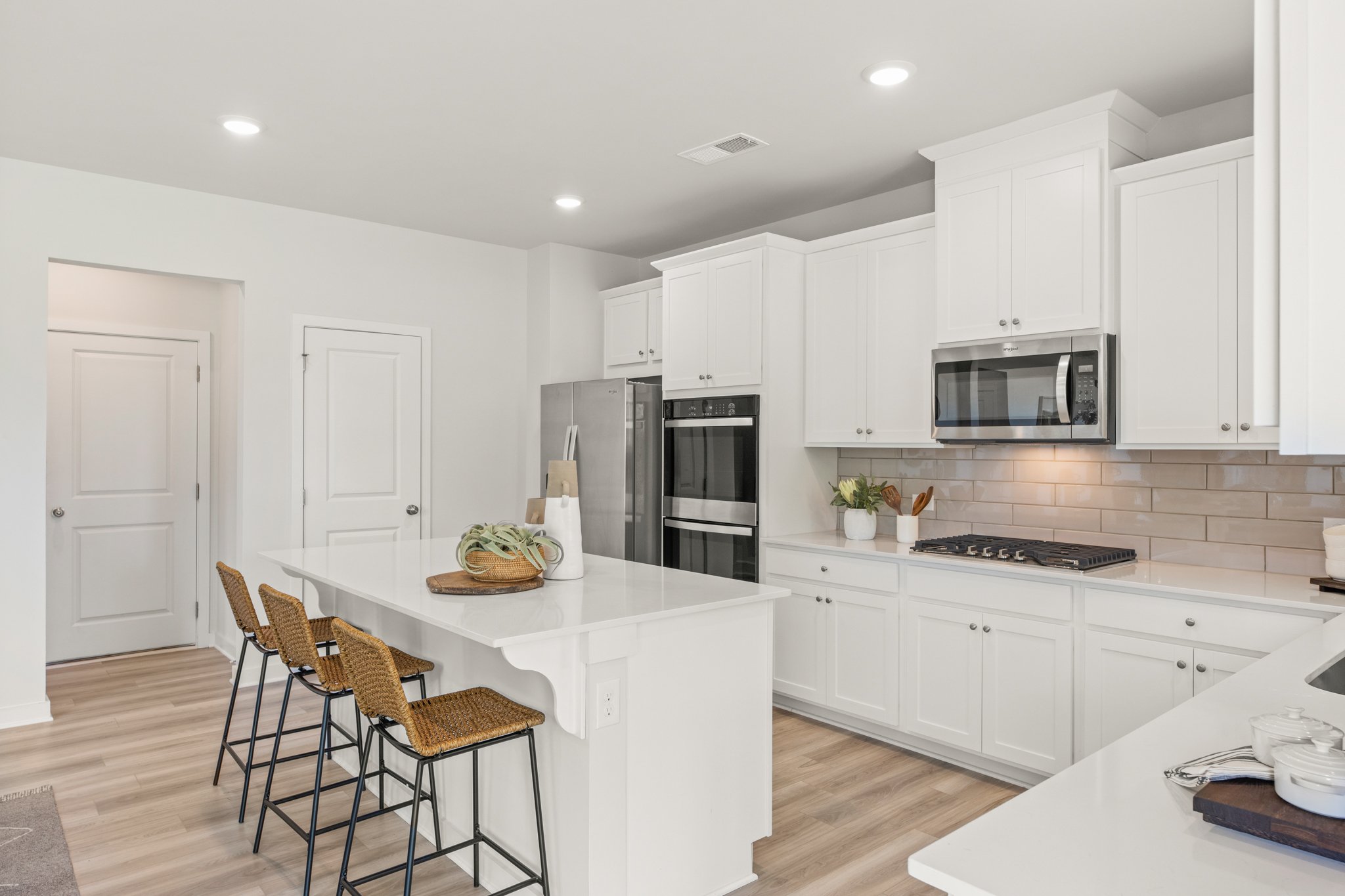 A kitchen with white cabinets.