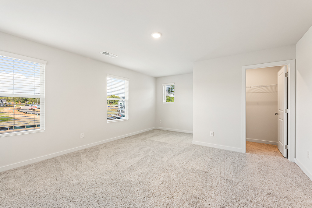A room with a carpet and windows.