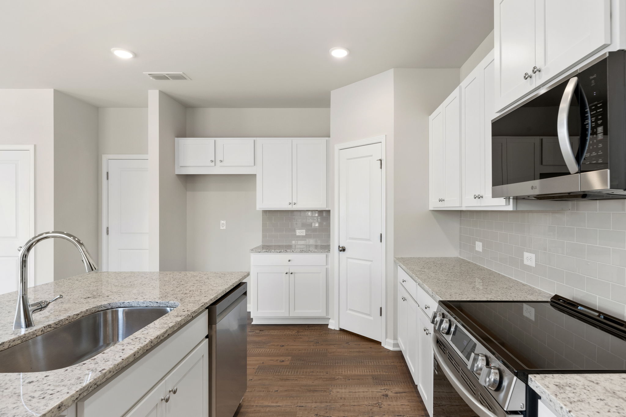 A kitchen with white cabinets.