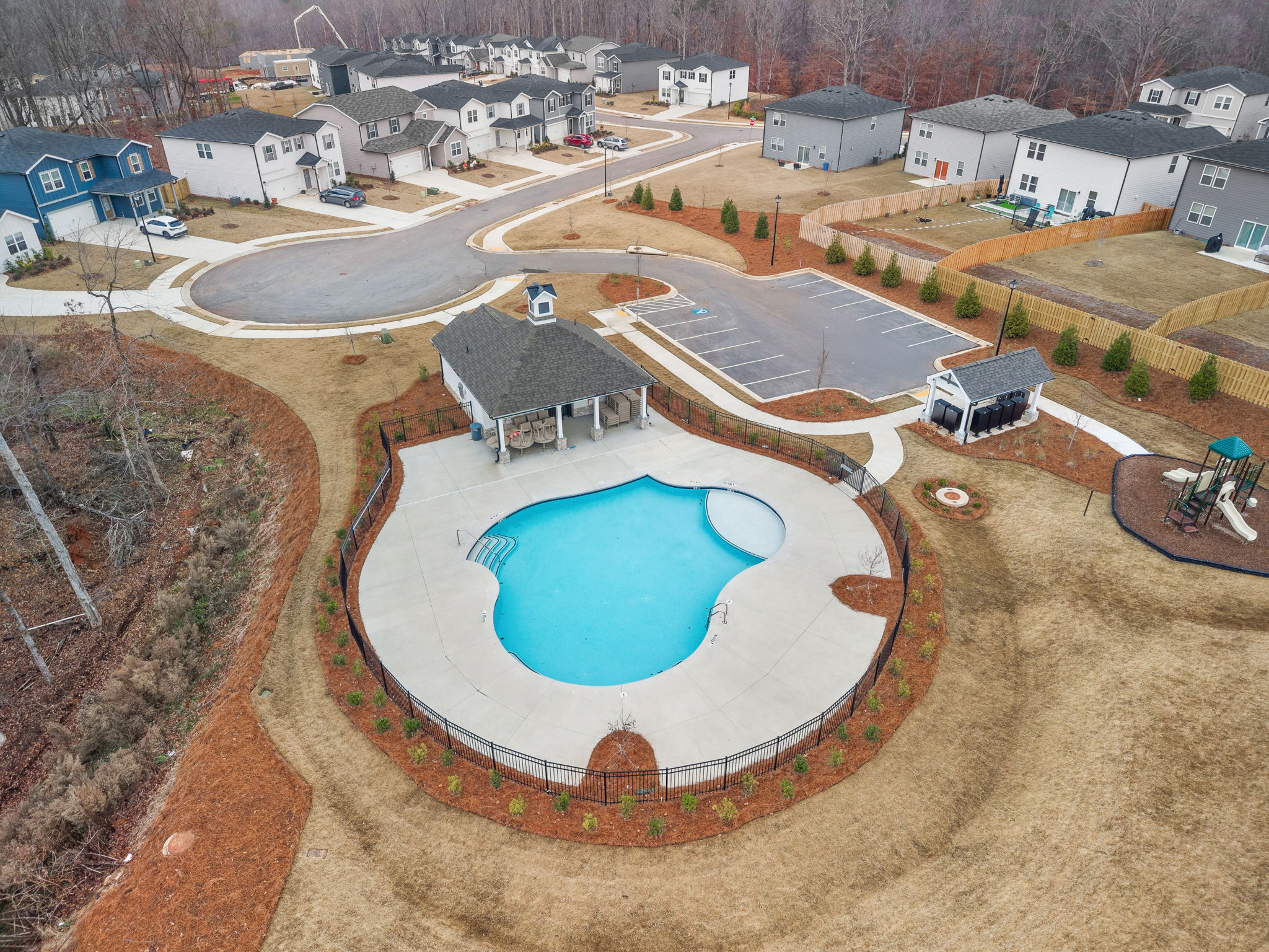 A circular hole in the ground with buildings in the background.