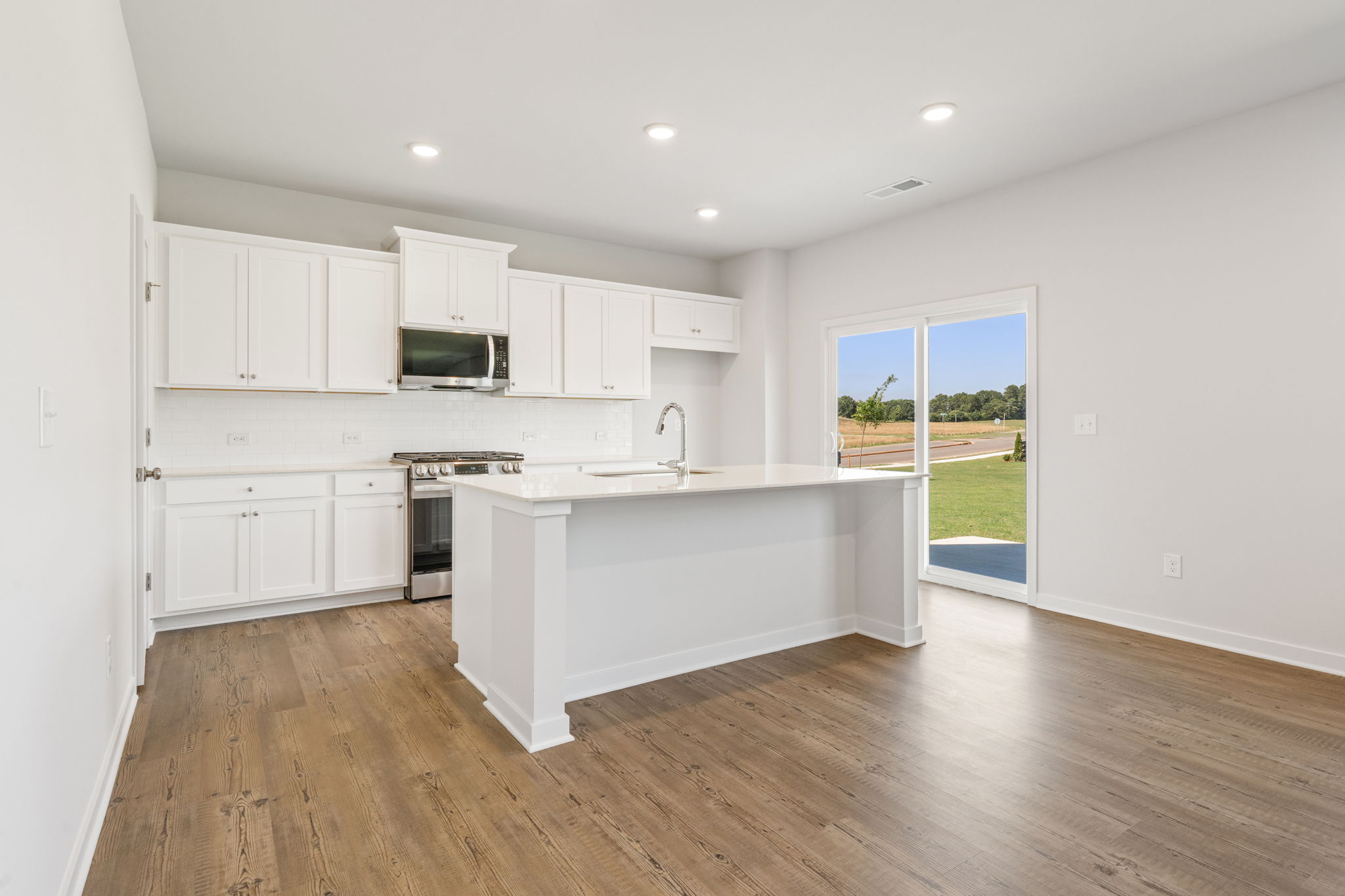 A kitchen with white cabinets.