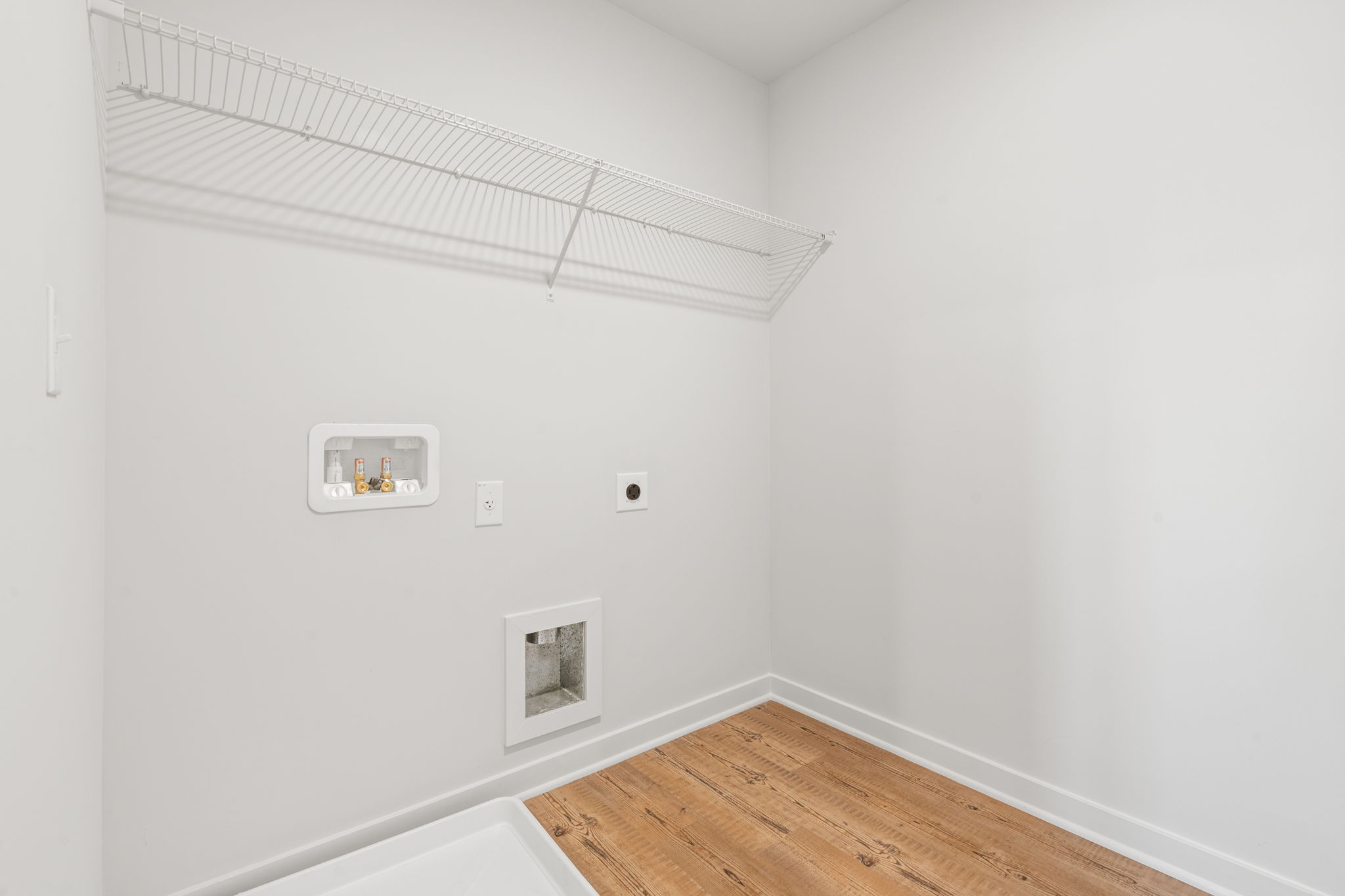 A white room with a wood floor and a wood floor.