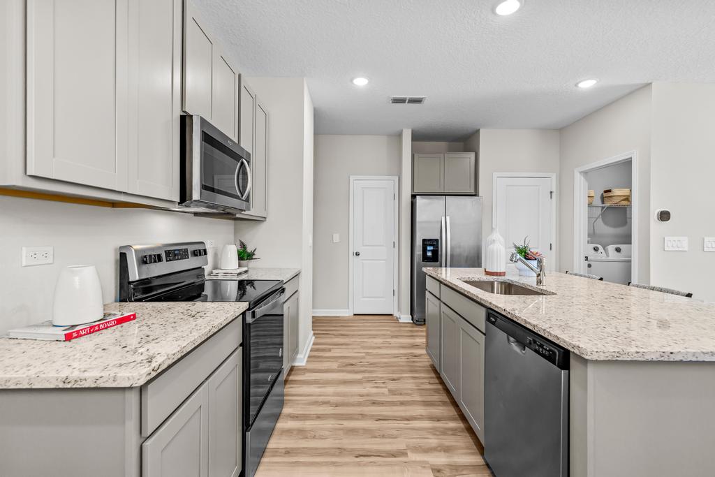 A kitchen with white cabinets.