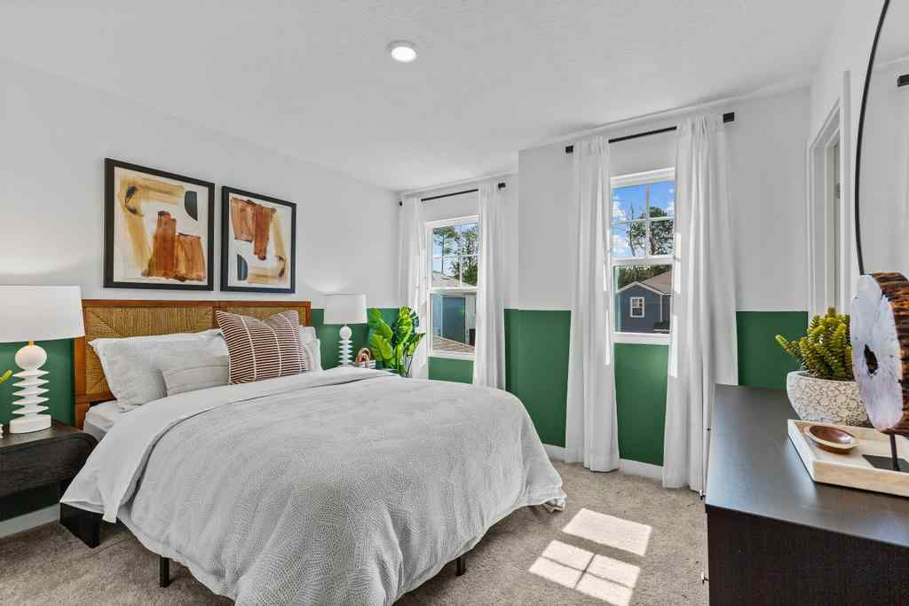 A bedroom with a bed and a lamp.