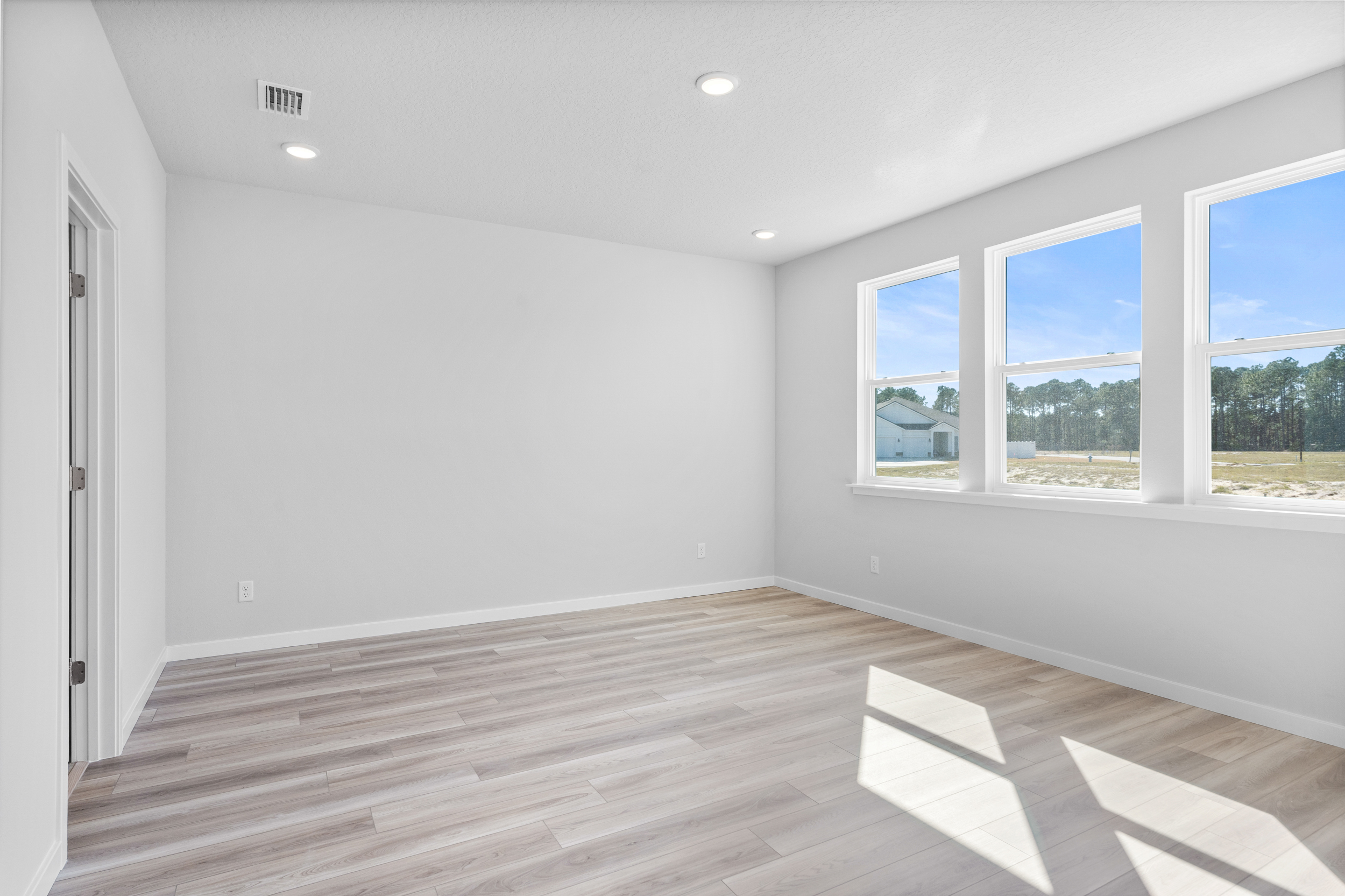Lot 199 Primary Bedroom with LVP Floors and 3 Large Windows at Reserve East
