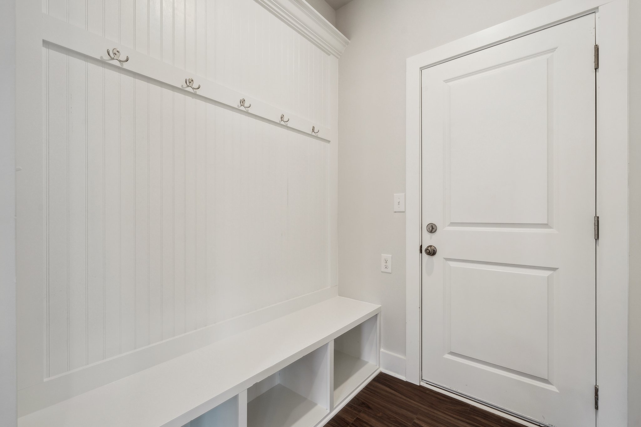 A white door next to a white wall.