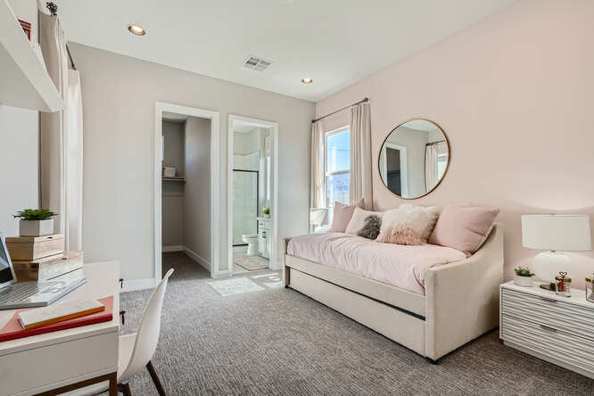 A room with a bed and a mirror.