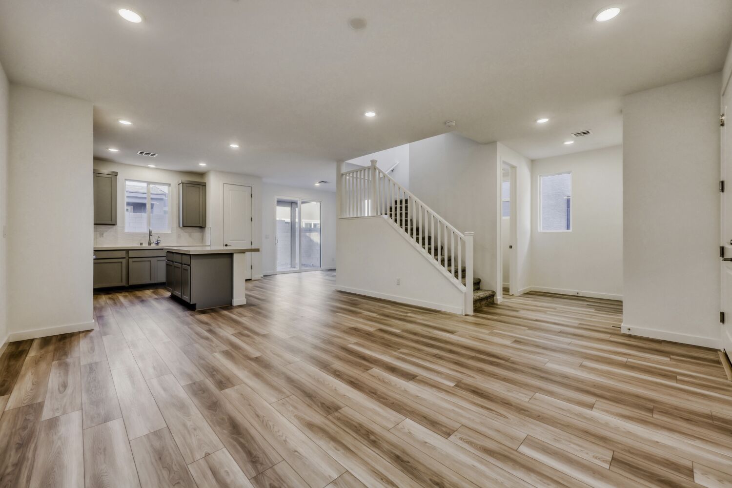 A large empty room with a wood floor and white walls.