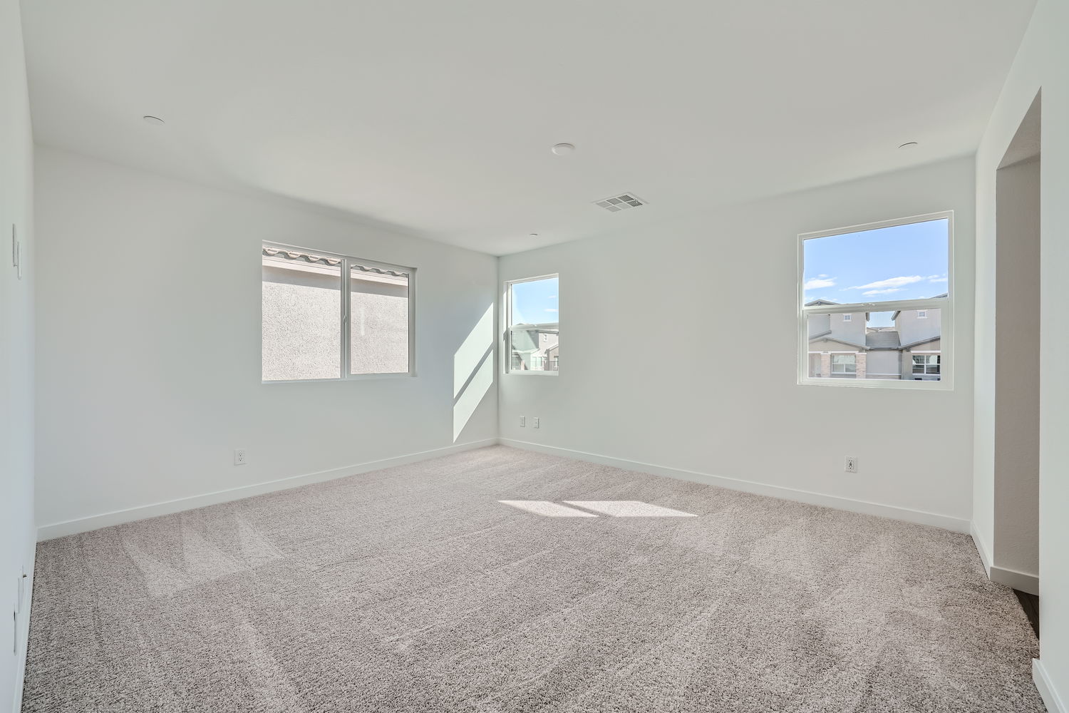 A room with a carpet and a window.