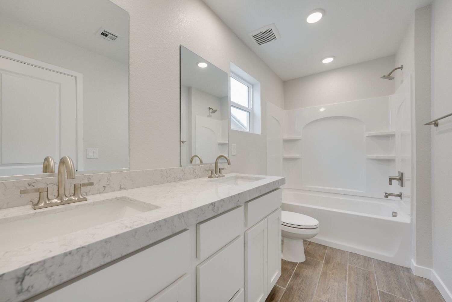 A bathroom with a tub sink and toilet.