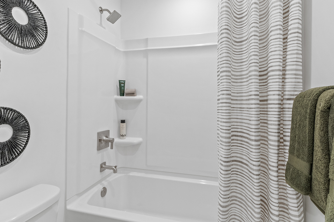 A bathroom with a white shower curtain.
