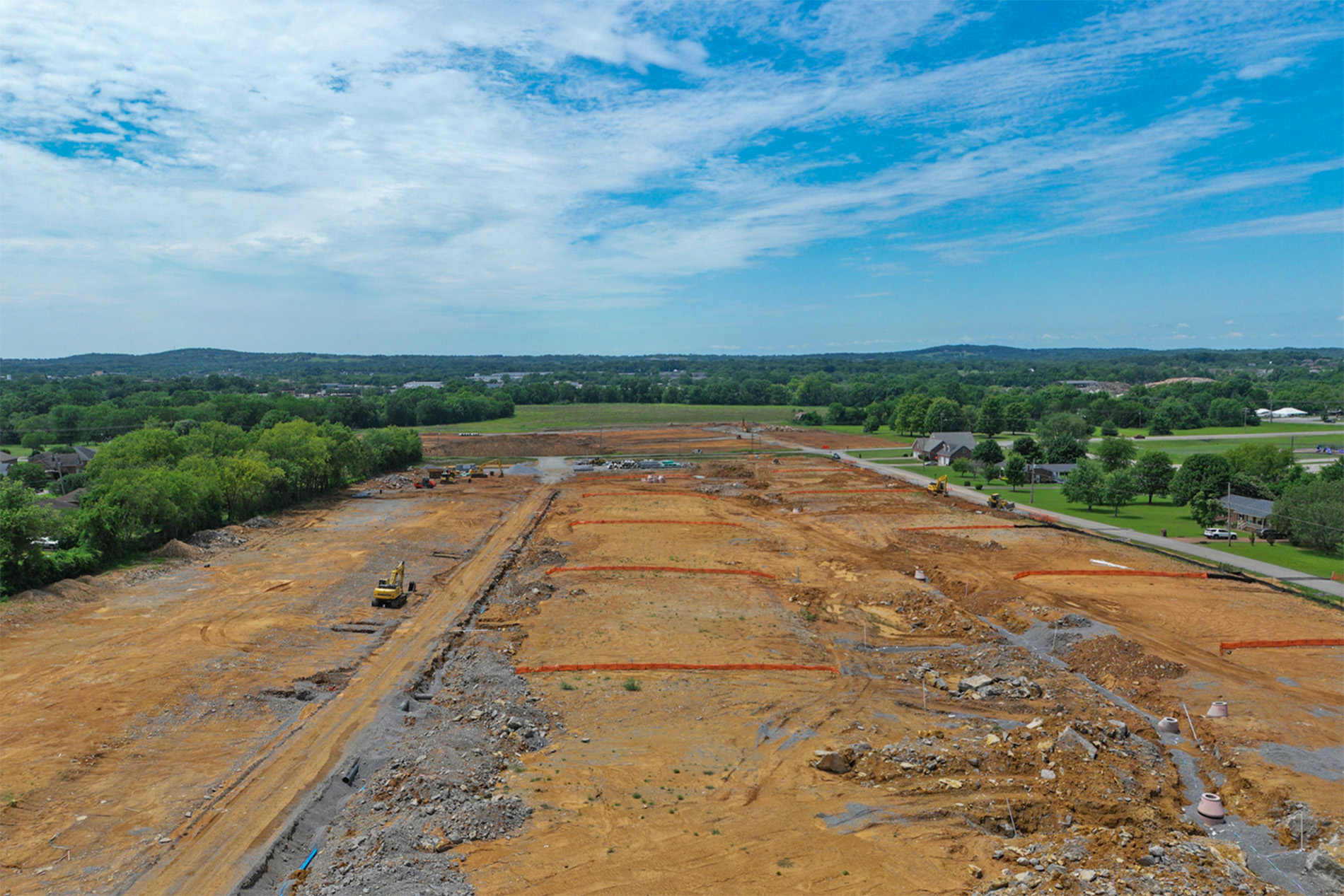 A dirt field with a few yellow machines.