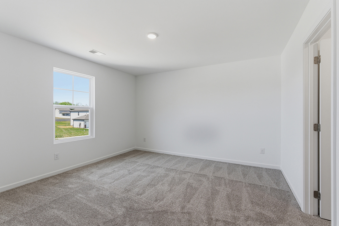 A room with a carpet and a window.