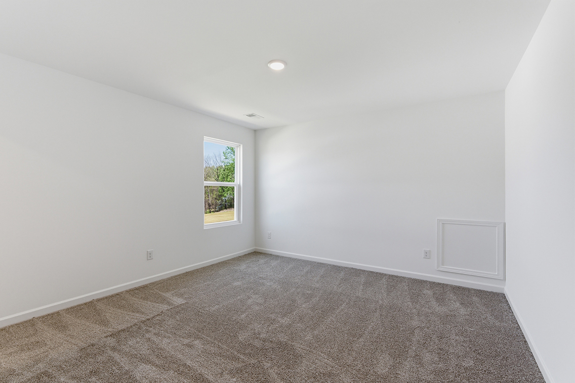 A room with a window and a carpet.