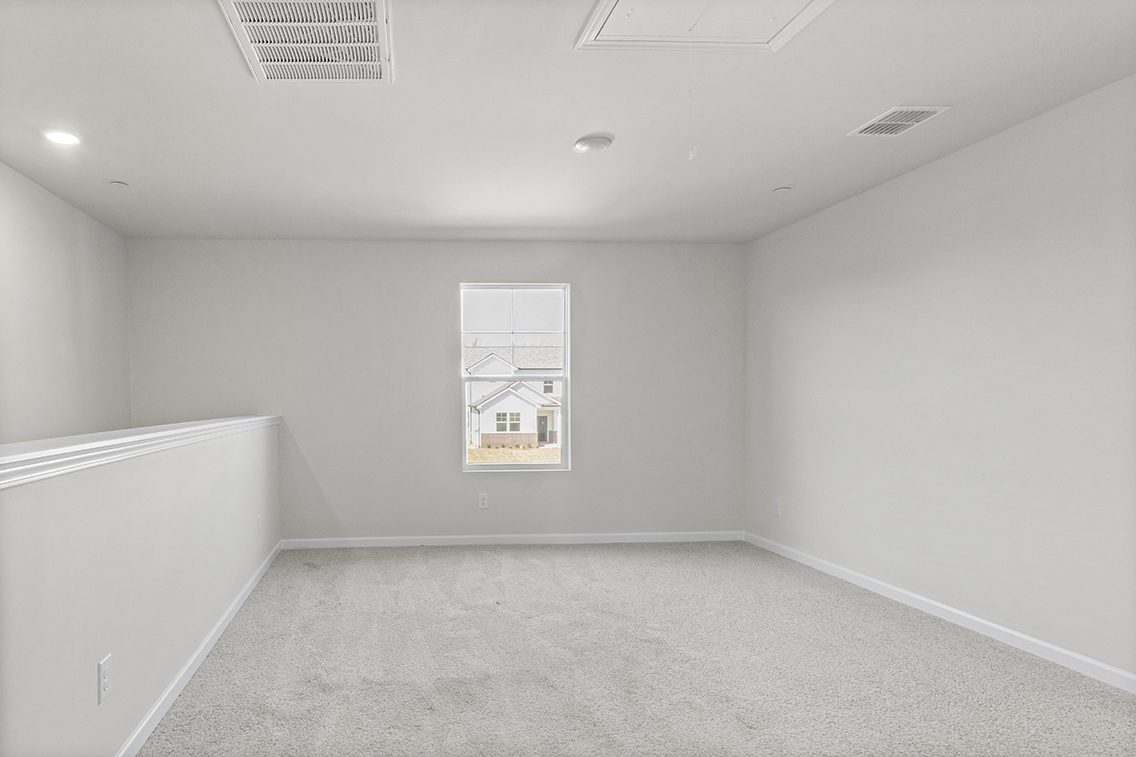 A room with a white wall and a painting on the wall.