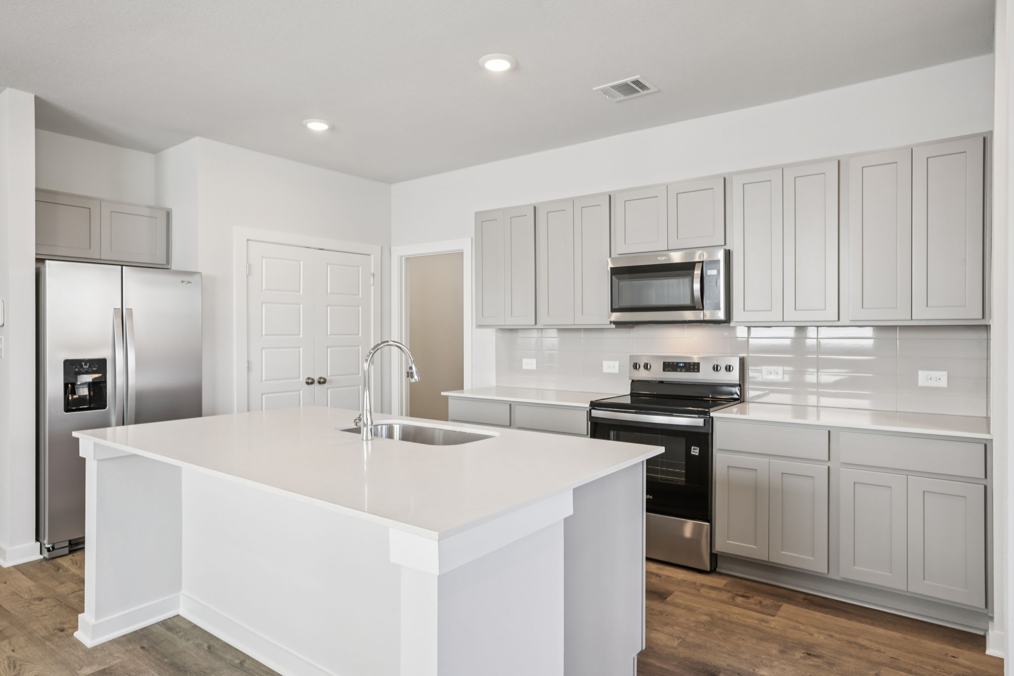 A kitchen with white cabinets.