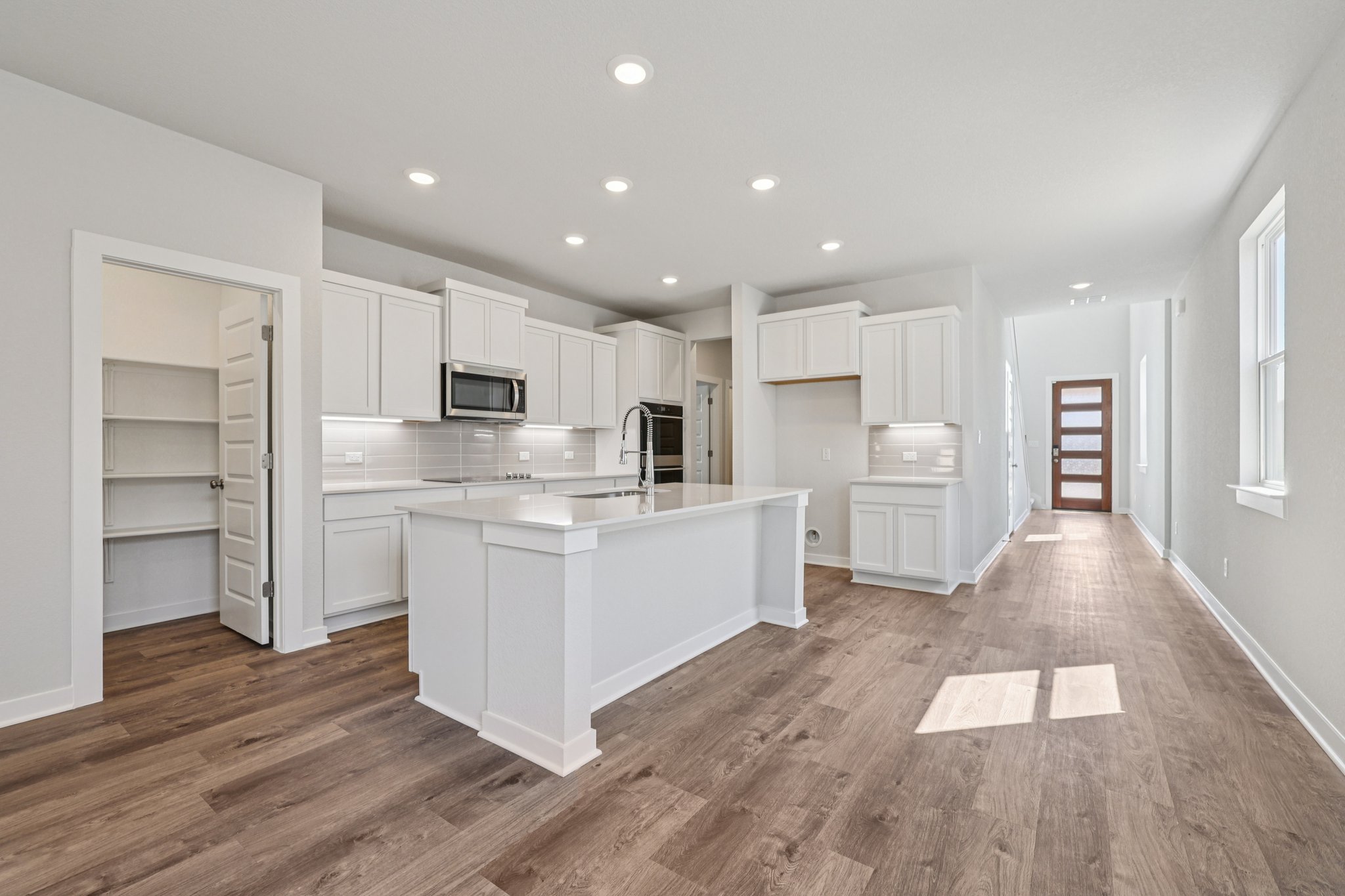 A kitchen with white cabinets.