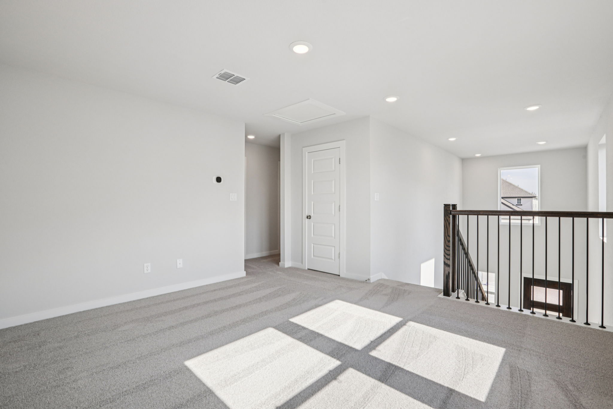 A room with a rug and a railing.