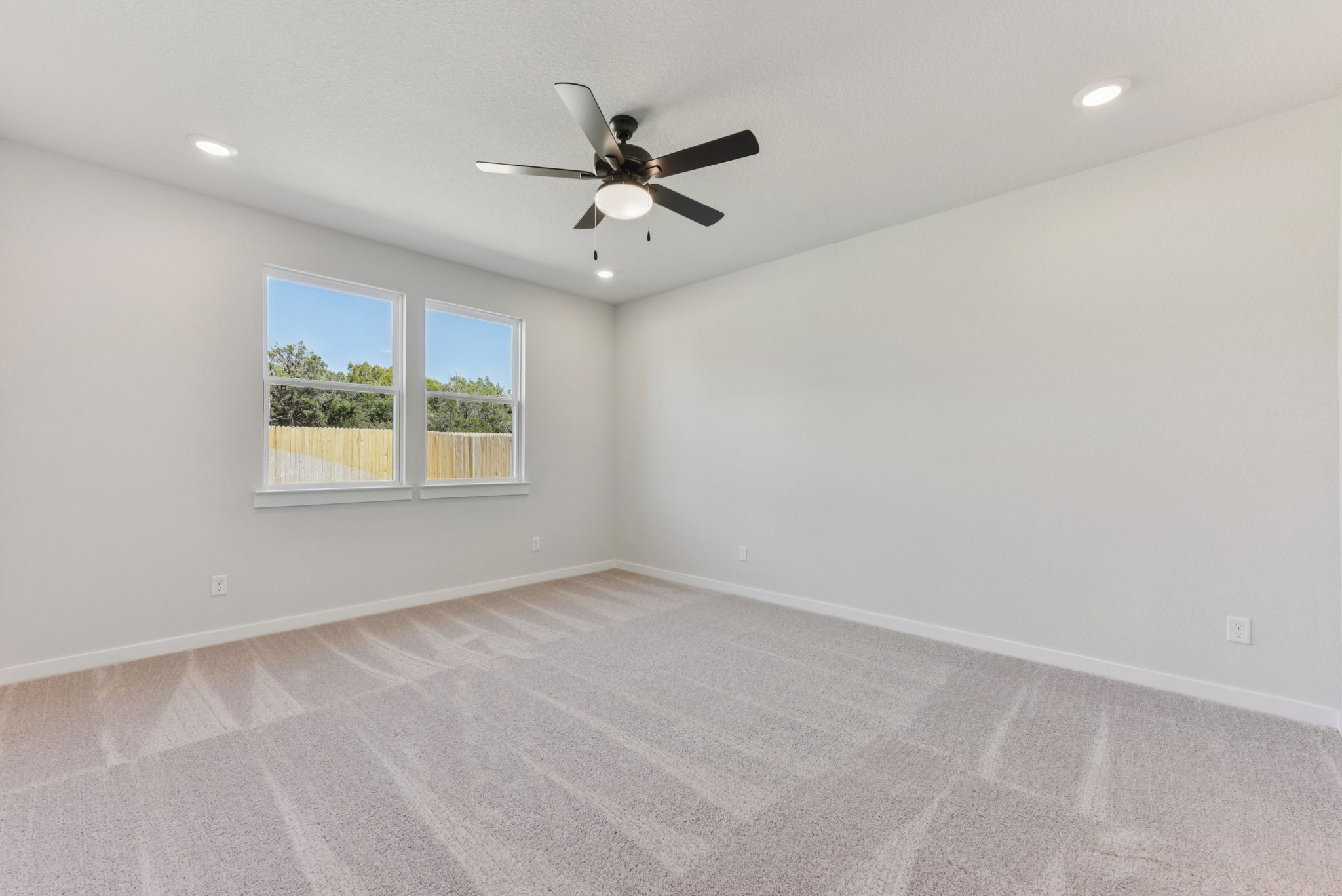 A room with a ceiling fan and a window.
