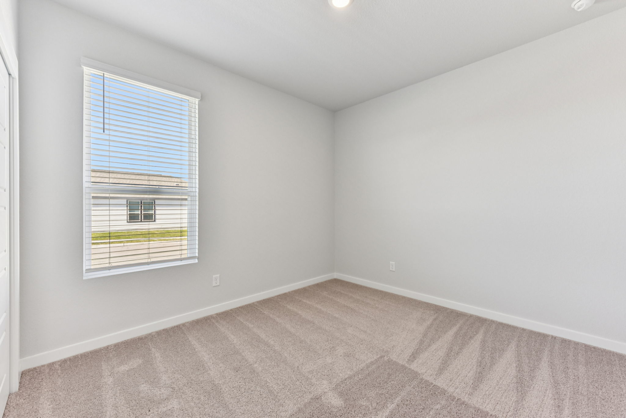 A room with a window and carpet.
