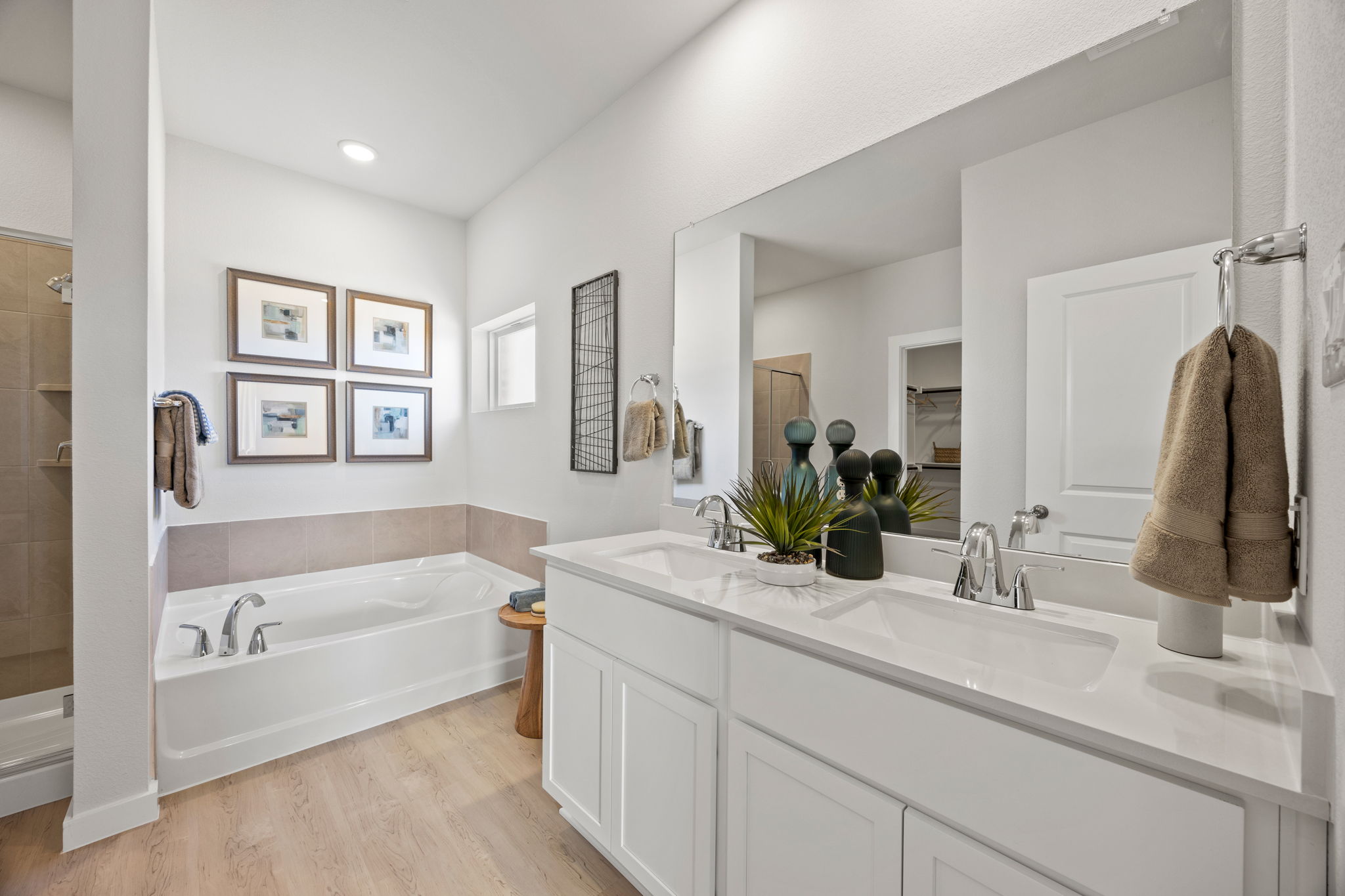 A bathroom with a tub sink and mirror.
