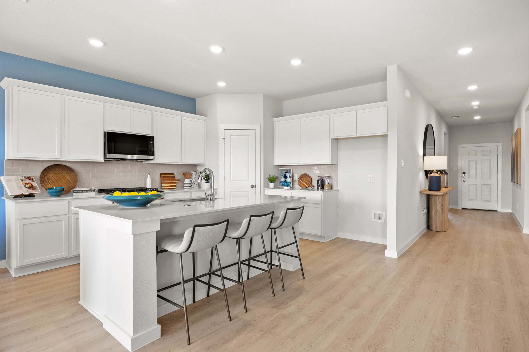 A kitchen with white cabinets.