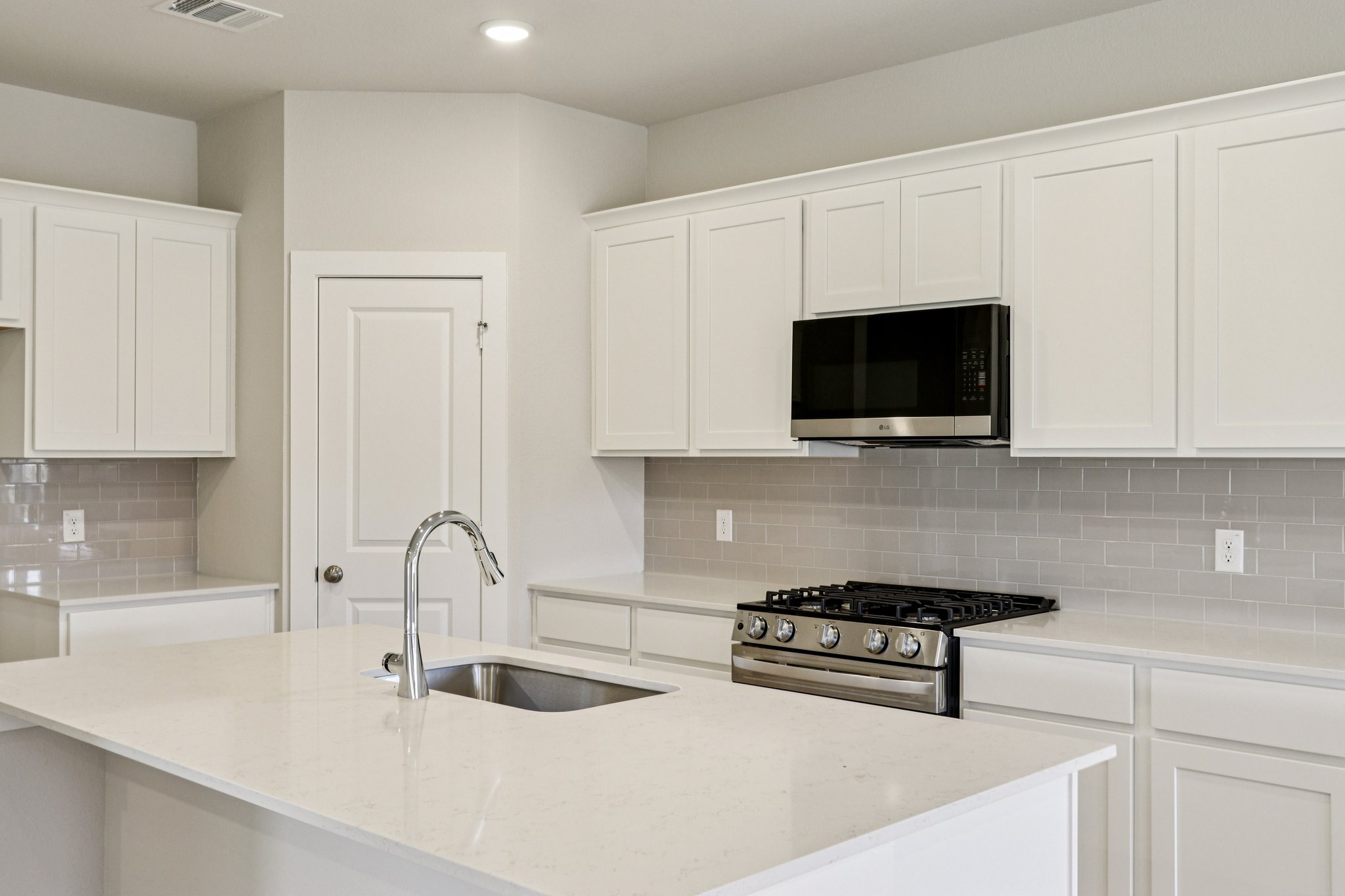 A kitchen with white cabinets.