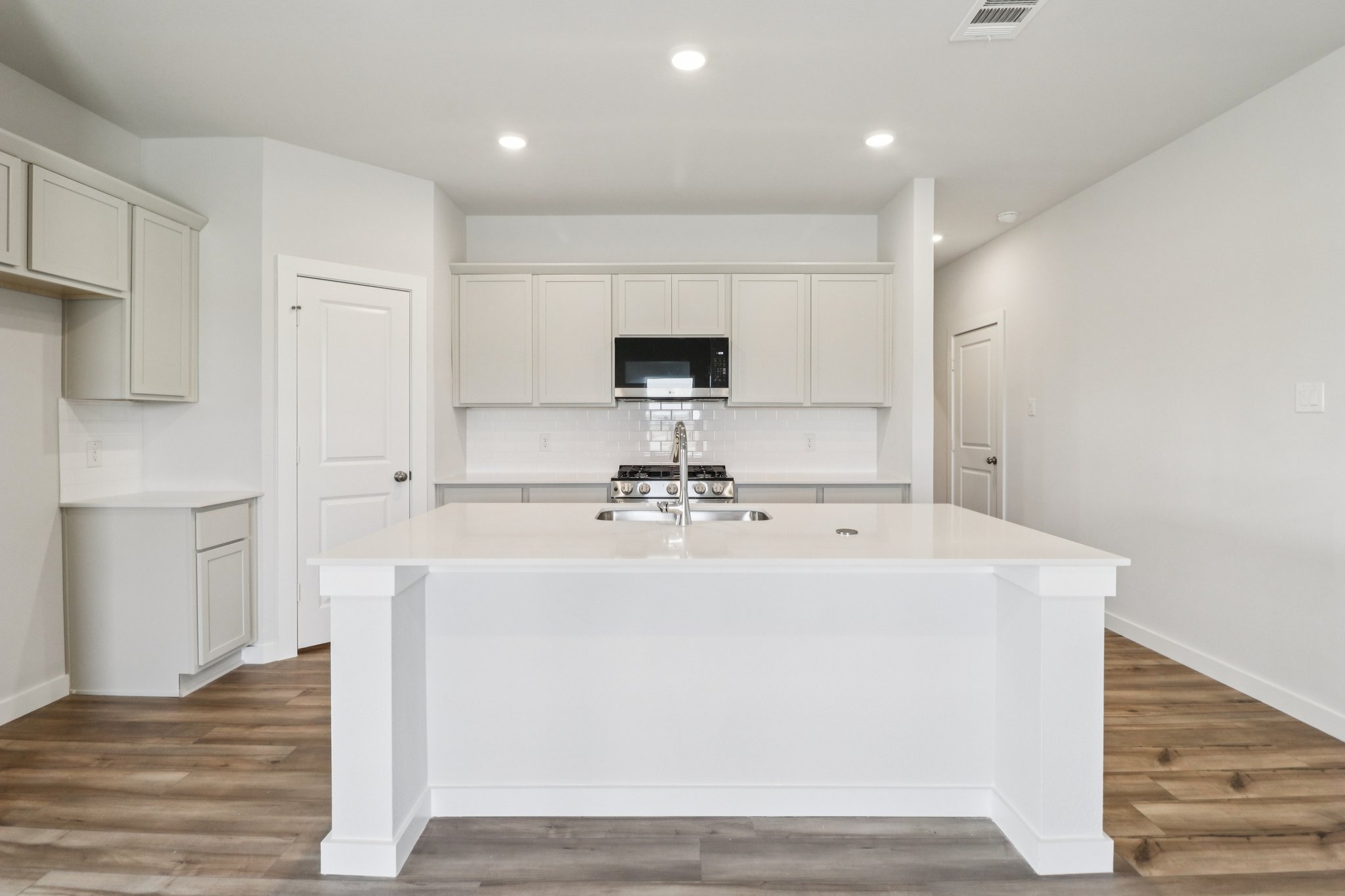 A kitchen with white cabinets.