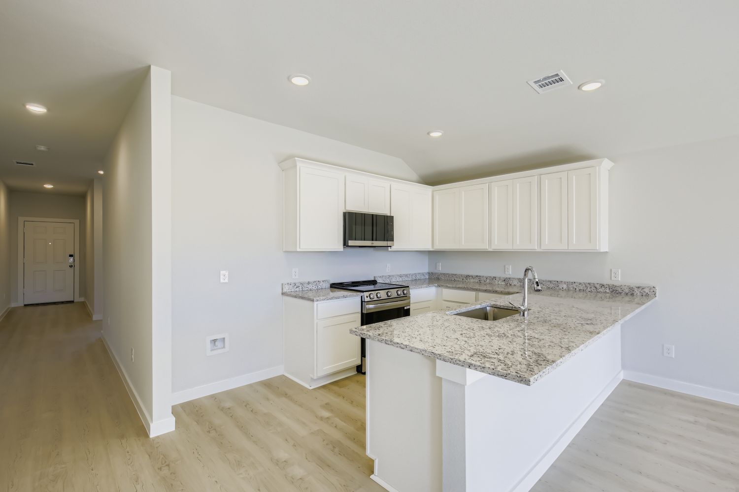 A kitchen with white cabinets.