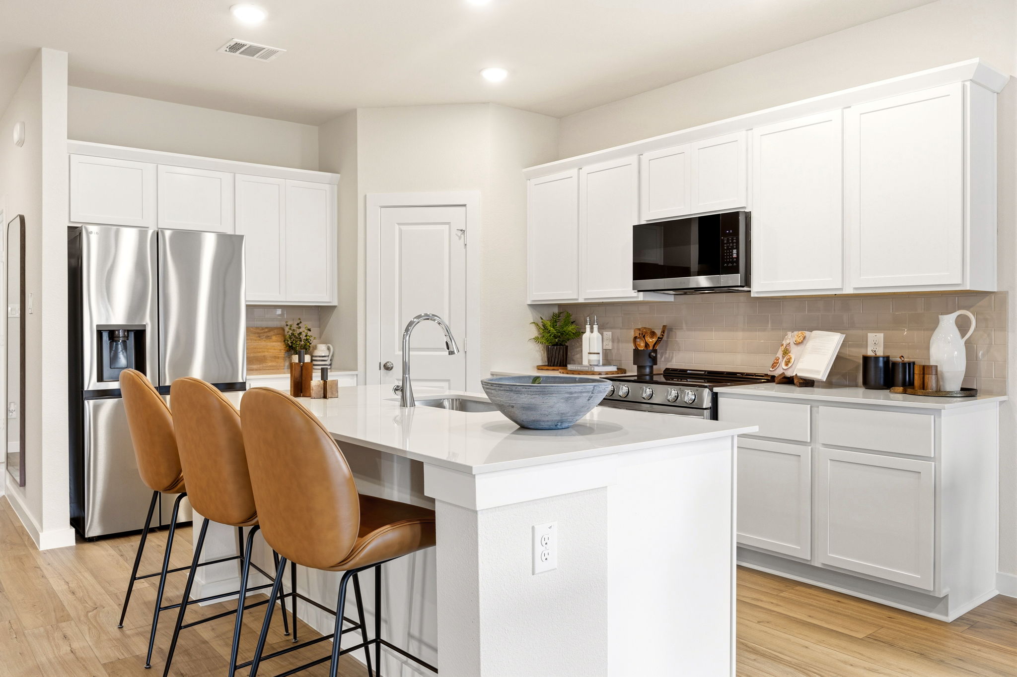 A kitchen with white cabinets.
