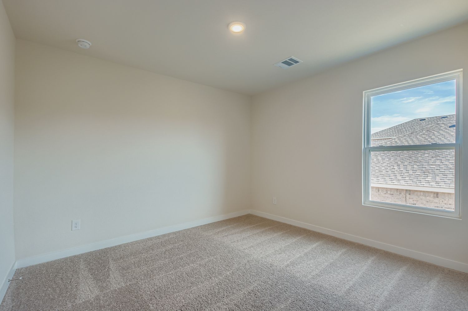 A room with a carpet and a window.