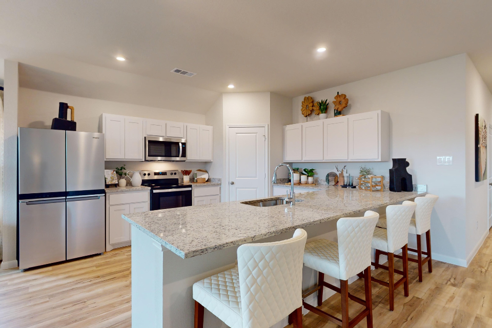 A kitchen with white cabinets.